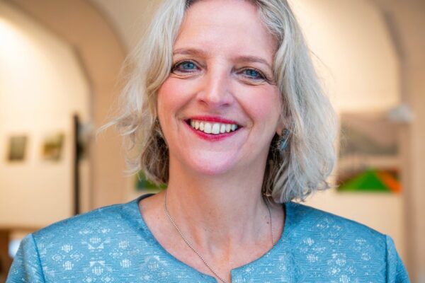 Portret van Marinka de Haan, glimlachend, in een lichtblauwe blouse