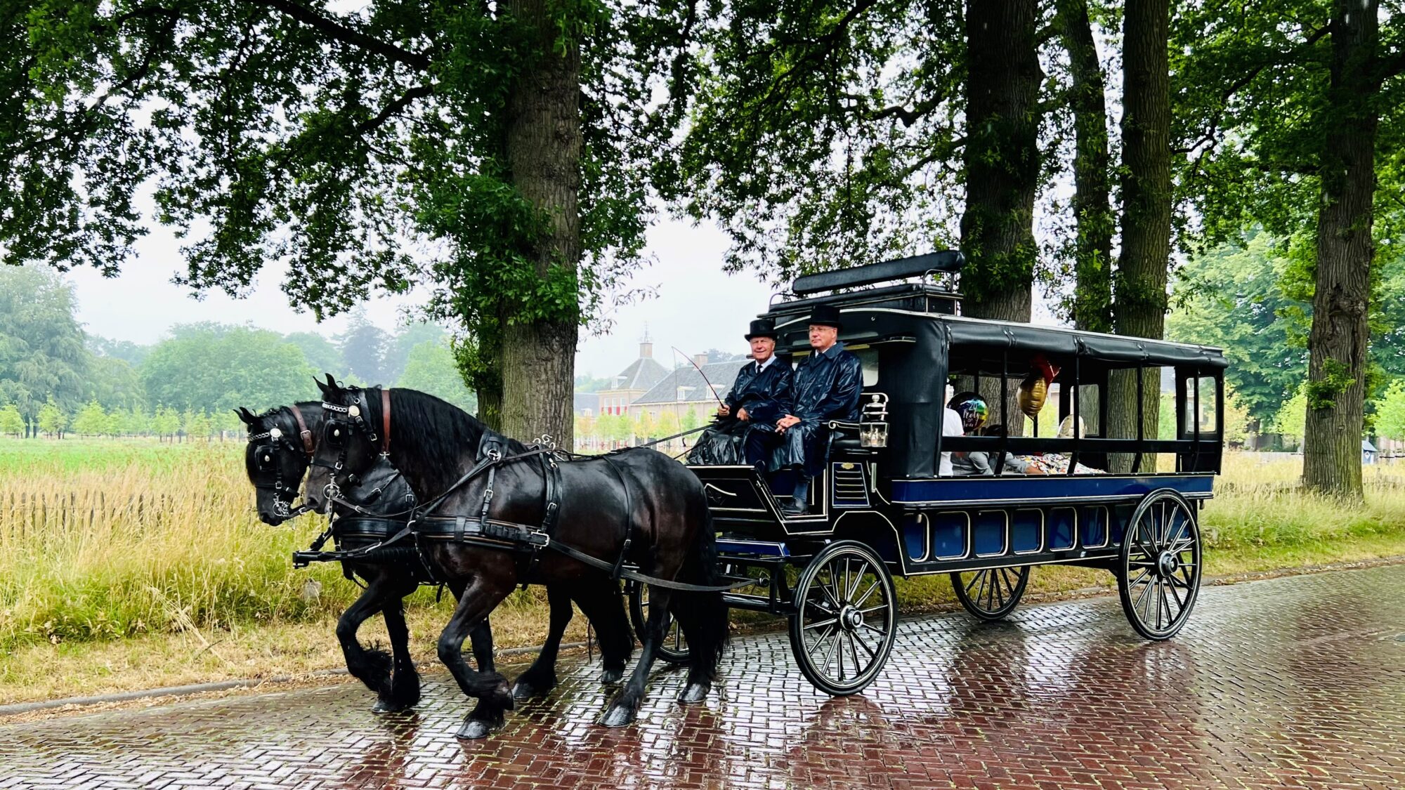 Een rouwkoets getrokken door twee zwarte paarden